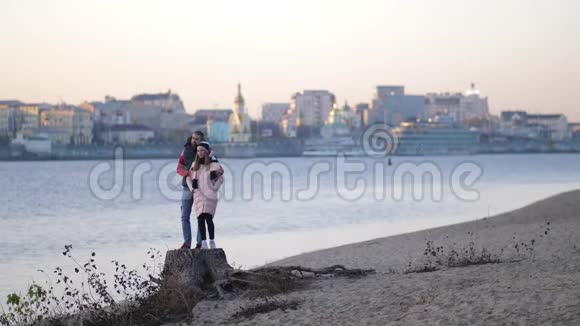 帅哥在海滩上拥抱一个年轻女孩这对夫妇正向前看微笑秋天4K慢莫视频的预览图