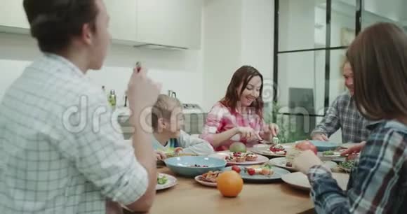 在现代的厨房餐桌上一个可爱的大家庭一起吃晚饭视频的预览图