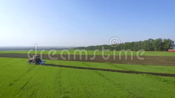 红拖拉机在绿田耕作土壤中的气弧喷丸视频的预览图