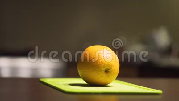 在一块浅绿色的木板上把橘子切成半片视频的预览图