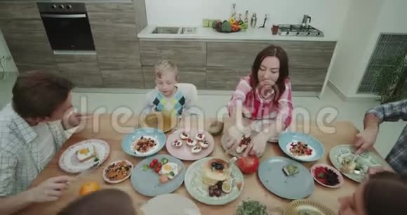 晚餐时间在一个大家庭也可以看到一起在桌子上供应和吃一顿美丽而多彩的食物视频的预览图