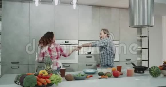 成熟的夫妇在厨房里尽情享受魅力同时在现代厨房设计中准备健康的早餐视频的预览图
