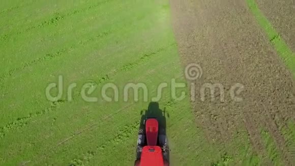 红拖拉机在绿田耕作土壤上的自上而下射击视频的预览图