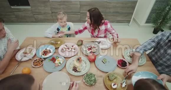 大家庭的顶景晚餐时间剪盘子吃美味的自制食物视频的预览图
