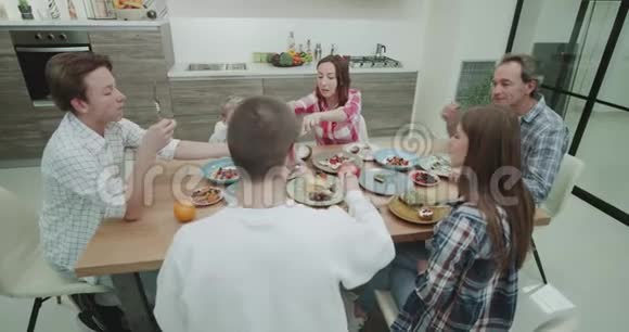 一个成熟的大家庭在一起吃晚饭他们一起在餐桌上度过一段美好的时光视频的预览图