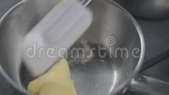 厨房里的煎锅上有一块奶酪生锈了厨师把食物和橡胶铲混合在一起食品准备视频的预览图
