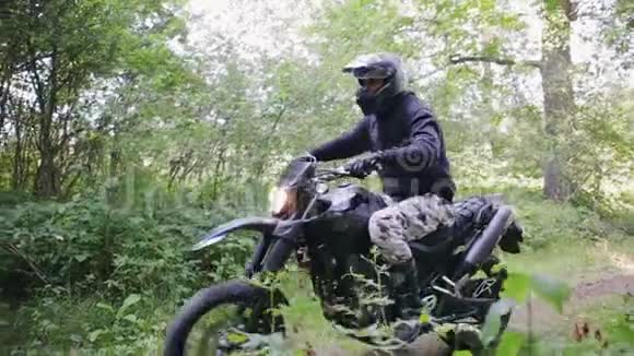 骑着防护装备的骑士骑着摩托车穿过茂密的森林视频的预览图