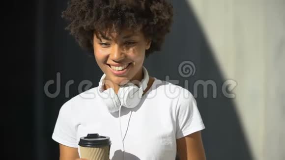 无忧无虑的美国女性捧着一杯茶对着镜头微笑调情视频的预览图