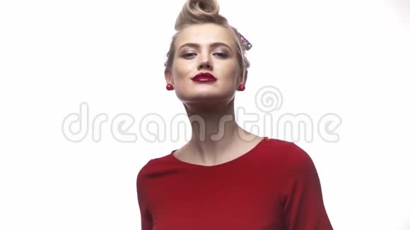 美丽的金发女孩带着红色唇膏和耳环穿着红色裙子慢动作视频的预览图