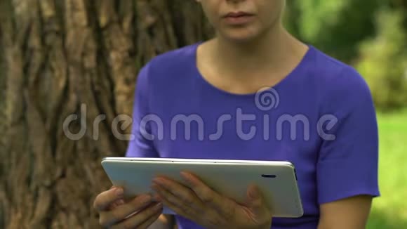 在公园里远程操作平板电脑查看电子邮件移动应用程序的女商人视频的预览图