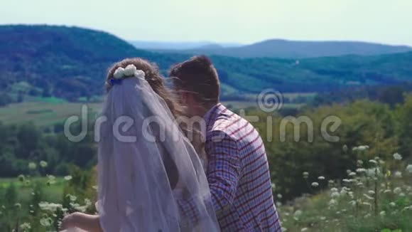 爱情故事新婚夫妇坐在长凳上看风景视频的预览图