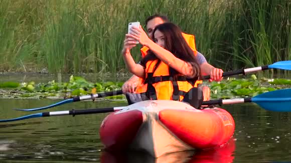 盖伊和女孩坐在皮艇里自拍慢动作视频的预览图