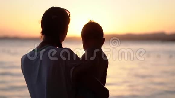 母亲在日落时缓慢地向她的小婴儿展示生命的美丽视频的预览图