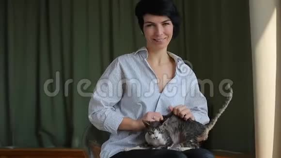 特写女孩和一只猫在椅子上玩耍视频的预览图