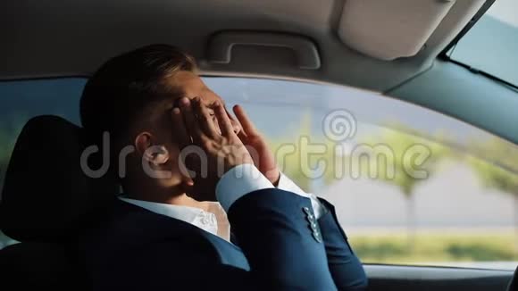 疲倦和压力很大的商人坐在车里头痛的人压力破产坏消息痛苦视频的预览图