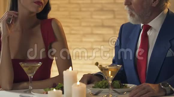 年轻女士与老百万富翁共进晚餐婚姻的便利概念视频的预览图