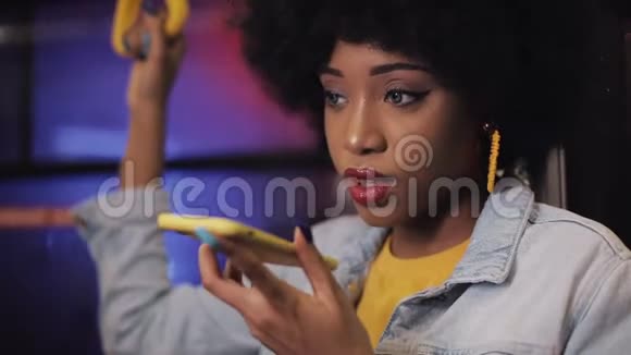 年轻的非洲裔美国妇女使用智能手机语音识别口述想法语音拨号信息骑在车里视频的预览图