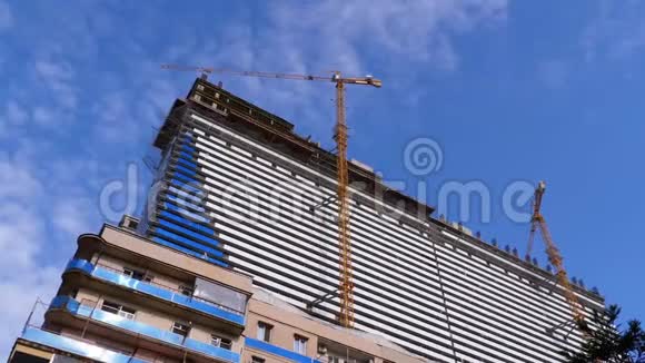蓝天上的起重机正在建造新的摩天大楼建筑施工视频的预览图
