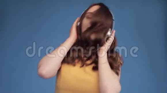 穿黄衬衫戴耳机听音乐的小女孩视频的预览图