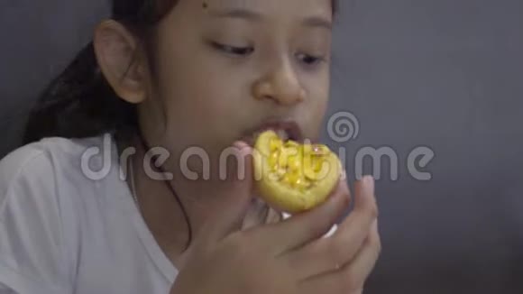 亚洲可爱的女孩吃甜食午餐时在餐馆里使用手机视频的预览图