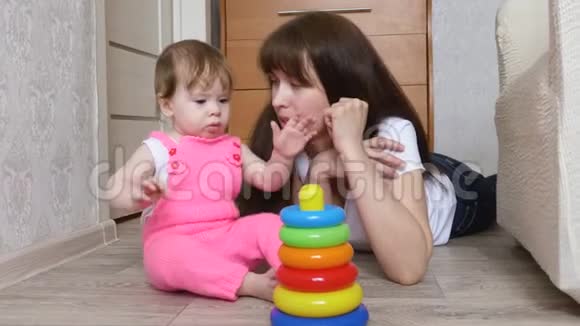 妈妈和小女儿在孩子们房间里玩五颜六色的金字塔视频的预览图