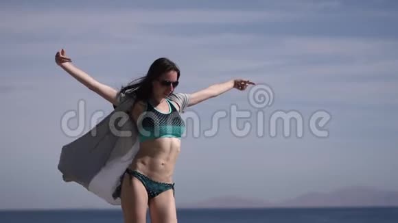 性感的女孩在海滩上跳舞并以缓慢的动作发送空气亲吻视频的预览图