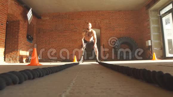 肌肉发达意志坚定在健身房用绳子训练视频的预览图