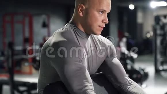 用杠铃做二头肌运动在健身房训练肌肉男视频的预览图