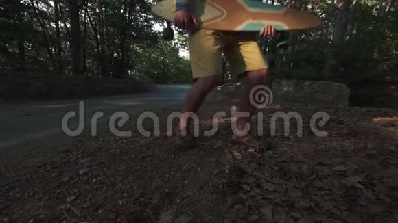 森林里的年轻嬉皮士用长板玩使用长板作为吉他像摇滚明星一样的驼峰乐趣视频的预览图