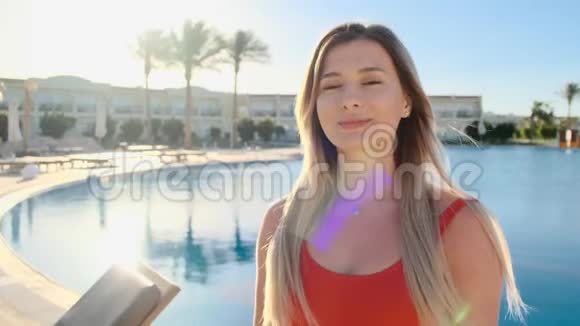 特写笑脸的少女画像看着镜头穿着红色泳衣的美女在蓝色游泳视频的预览图