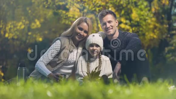 传统家庭在公园野餐微笑着看相机保险视频的预览图