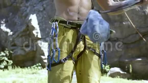 强壮的攀岩者赤裸的躯干准备在悬崖上进行户外攀岩并穿上粉笔袋视频的预览图