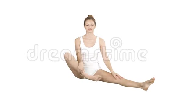 可爱的健身女练瑜珈坐在莲花的姿势和微笑后白色背景视频的预览图
