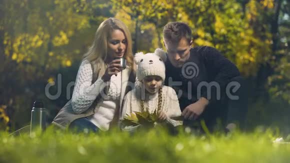 家庭在秋天的森林里野餐有意识的父母幸福视频的预览图