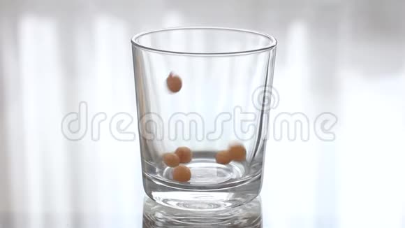 炸丸子正倒进一个透明的空玻璃杯里把腹股沟倒进透明的玻璃杯里视频的预览图