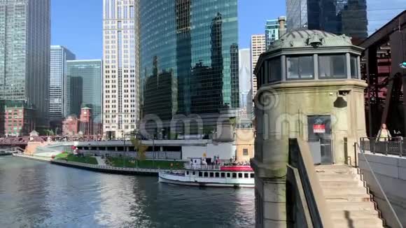 旅游船穿过湖街大桥下在那里通勤者匆匆忙忙el火车在芝加哥河上的轨道上行驶视频的预览图