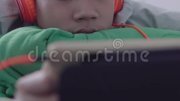 年轻的亚洲快乐男孩用笑脸在平板电脑上视频的预览图