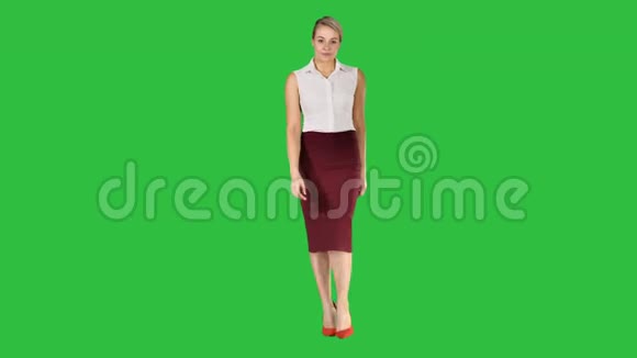 美丽的黑发女子商务办公风格时尚服装行走和微笑的镜头上的绿色屏幕视频的预览图