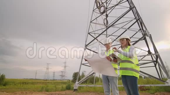 在输电线路附近的田地里有一名电工男女他是一名电工负责管理视频的预览图