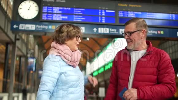 在火车站快乐的老年夫妇女人为即将到来的旅行感到高兴拥抱并感谢男人家庭视频的预览图