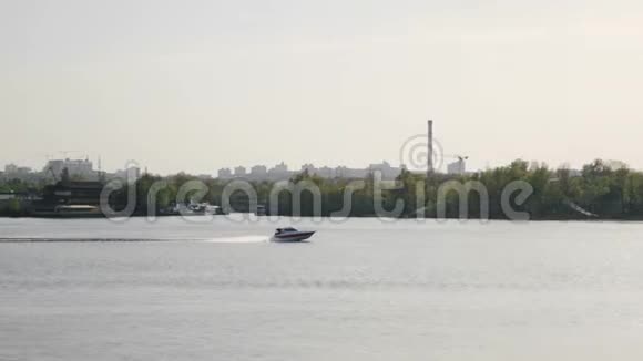 快速摩托艇快速地在河上向桥上漂浮工业城市的背景视频的预览图