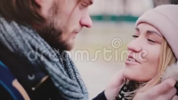 在寒冷的一天幸福的微笑年轻的欧洲浪漫夫妇站在一起在外面交谈视频的预览图
