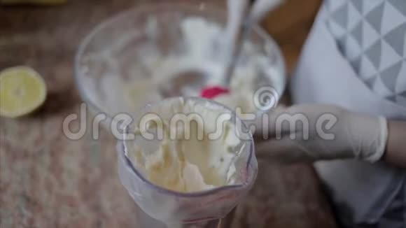 女人把混合奶油放进玻璃纸包里装饰蛋糕视频的预览图