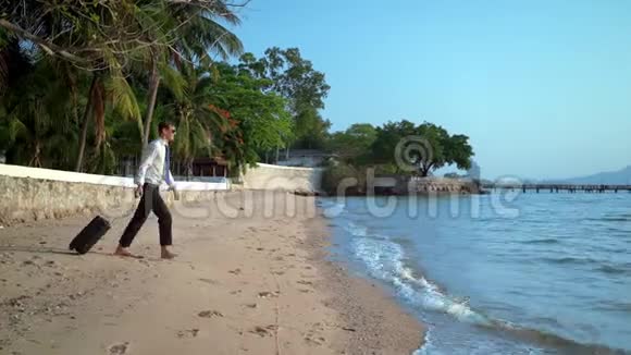 一个穿着西装戴着墨镜的快乐商人正在豪华度假胜地的海里溅水期待已久的假期概念视频的预览图