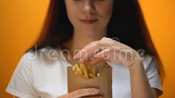 女孩吃炸薯条享受快餐高热量膳食肥胖风险视频的预览图