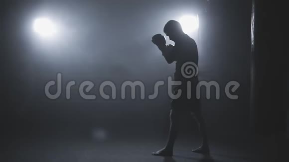在斯洛莫低光体育馆进行踢腿拳击训练运动员在烟雾缭绕的体育馆进行拳击训练视频的预览图