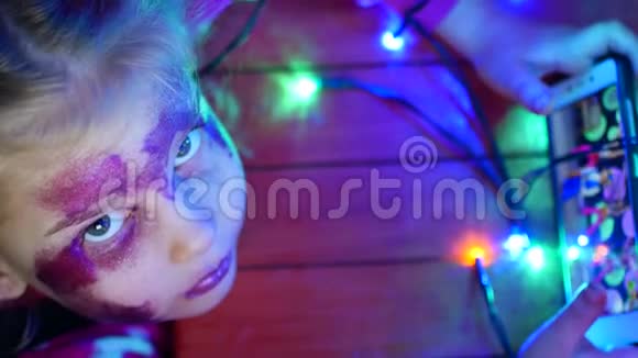 金发小女孩坐在地板上玩游戏节日房间的内部新年花环在地板上视频的预览图