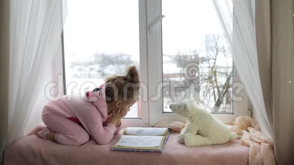 穿着粉色睡衣看书的小女孩视频的预览图