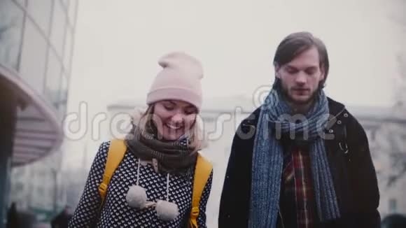 慢动作快乐微笑年轻的欧洲男人和女人一起散步在一个寒冷的雪冬的约会中玩得很开心视频的预览图