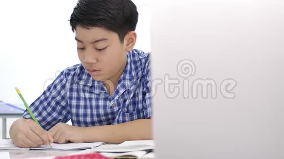 亚洲可爱的男孩做你的家庭作业微笑的脸在家4K多莉射击视频的预览图